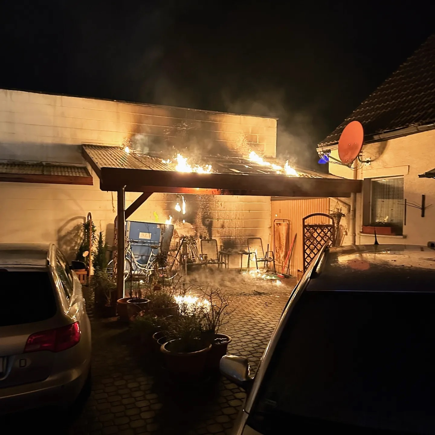 Brennt Carport - droht auf Gebäude überzugreifen